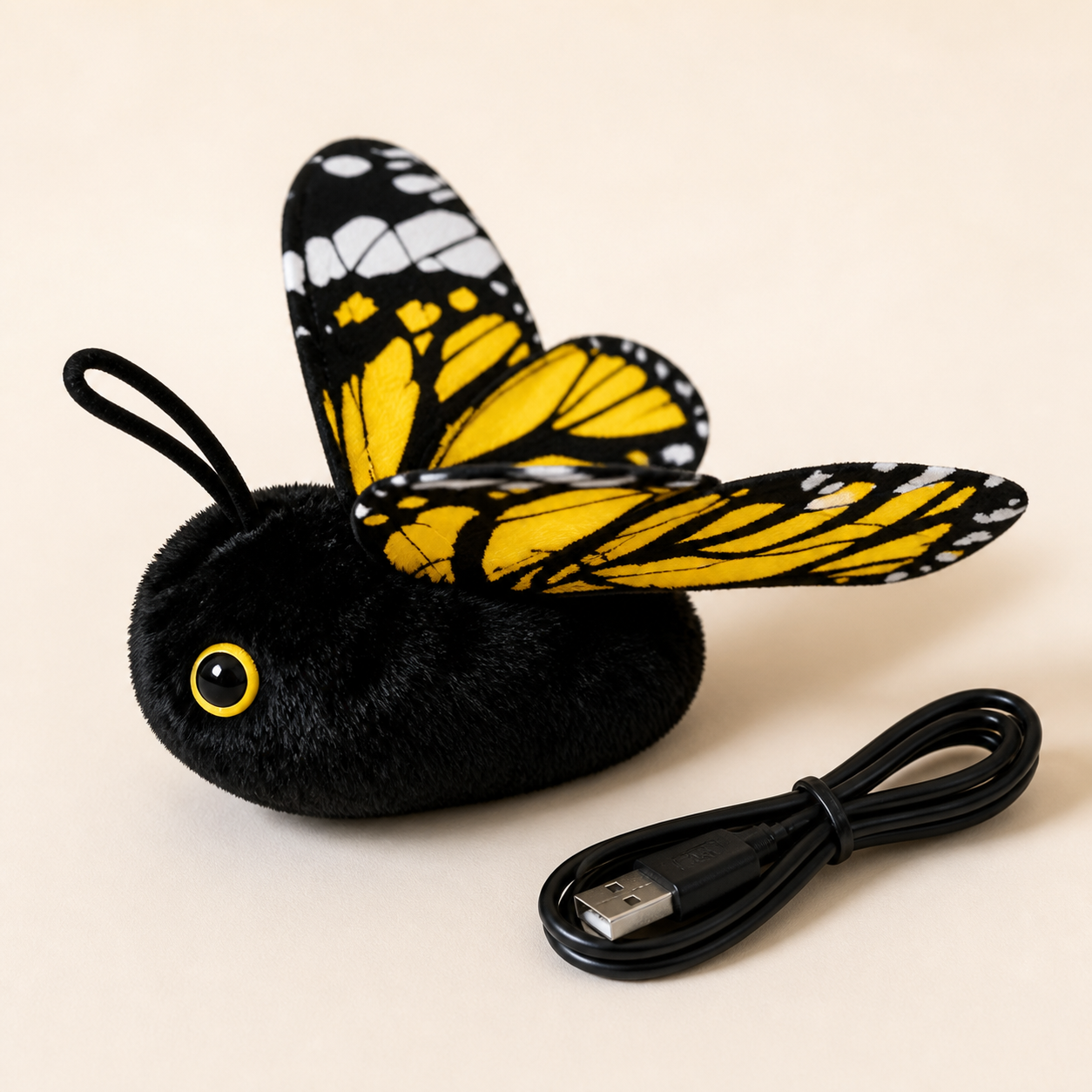 Close view of the black plush FlutterBloom butterfly toy with USB charging cable
